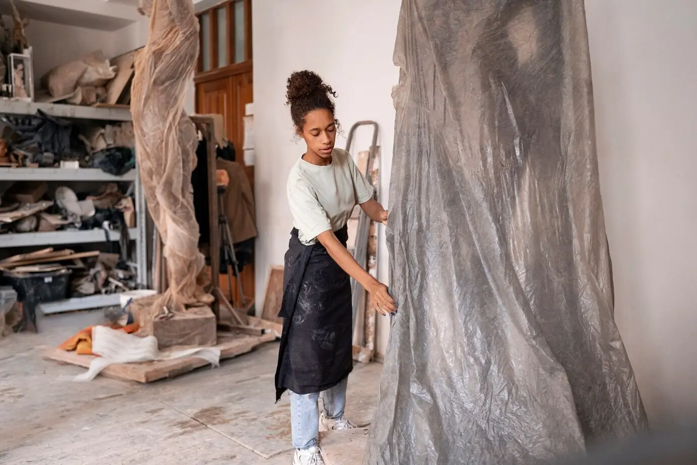 Ganzkörperaufnahme einer Frau beim Tonmodellieren.